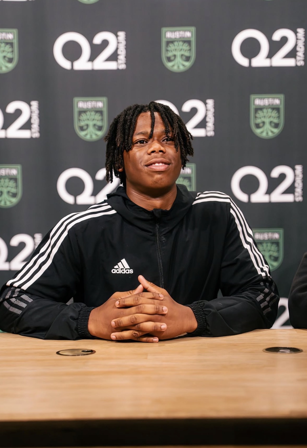 Young man at a press table at Q2 Stadium