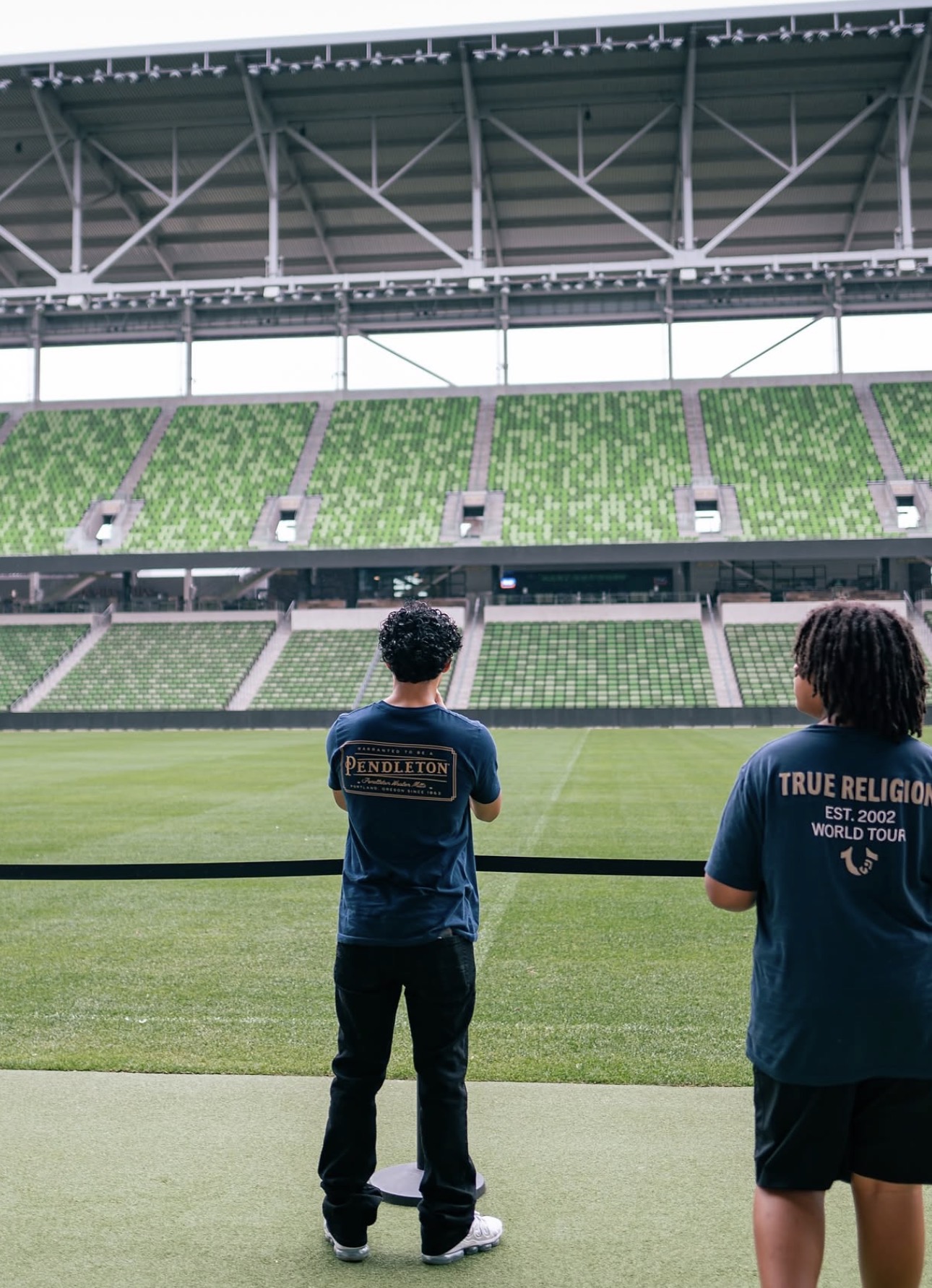 Two young people looking out over a professional stadium