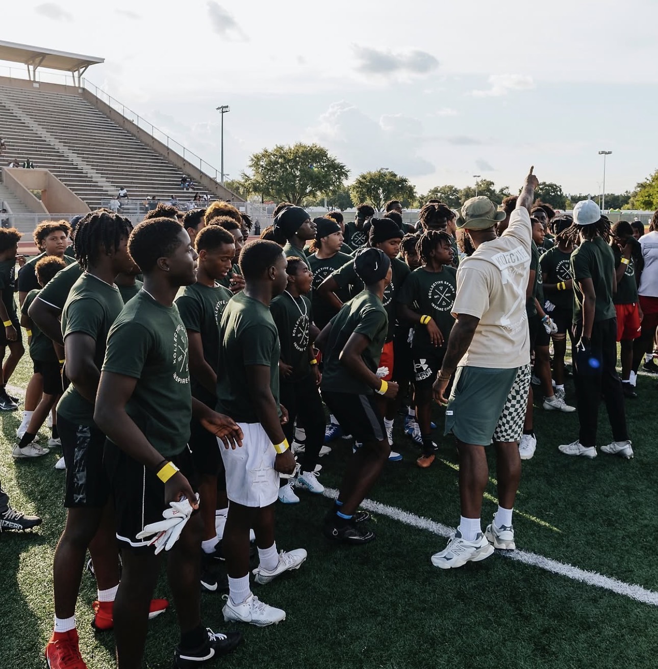 Coach leading a large group of youth on a field